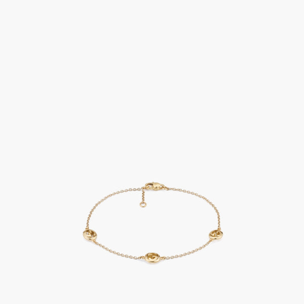 Gucci Interlocking Station Bracelet in yellow gold featuring three interlocking G logo stations spaced along a delicate chain with lobster clasp closure