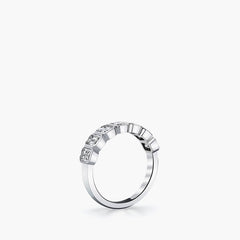 Seven-stone emerald-cut diamond bezel-set eternity band in 18K white gold, side view